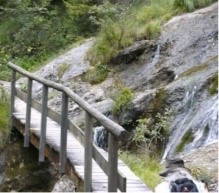 kleine Holzbrücke über einen Gebirgsbach am Felsenrand